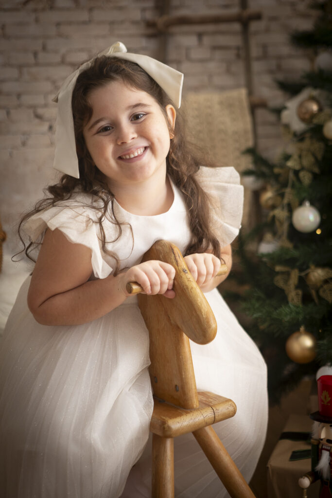 bimba su cavallino di legno con albero di natale (1 di 1)