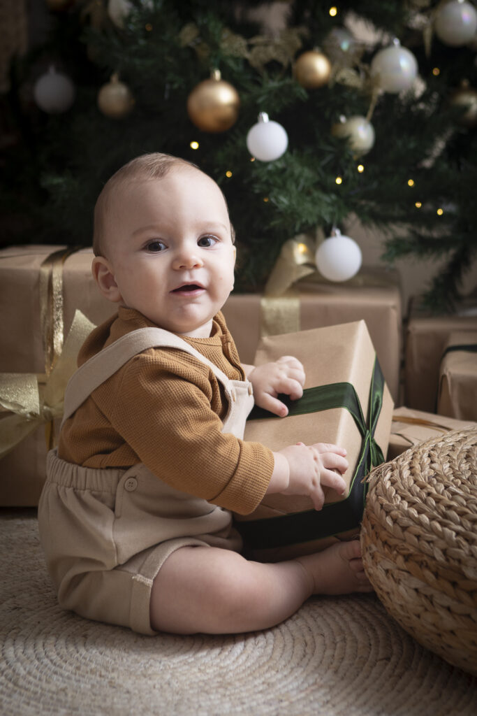 bimbo piccolo davanti all' albero di natale con pacchetto regalo (1 di 1)